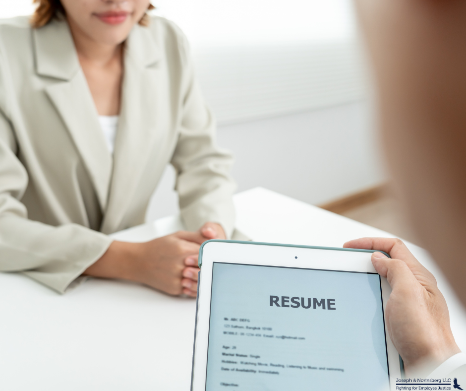 A recruiter looking at a resume and interviewing a candidate