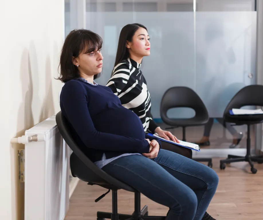 Two pregnant women sitting in a waiting room
