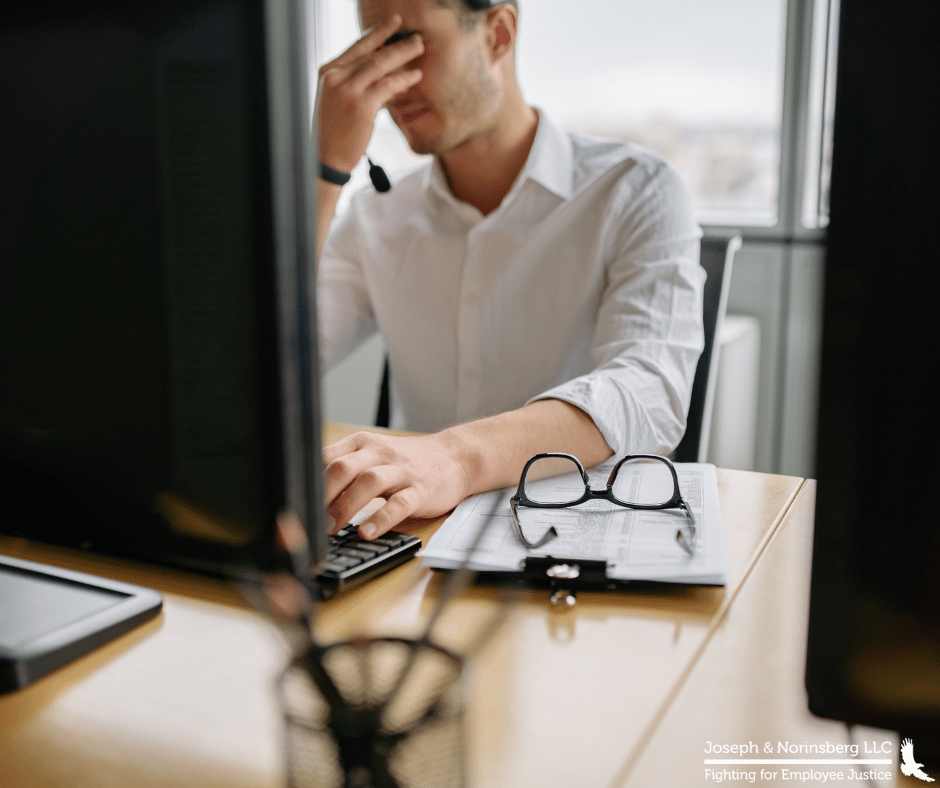 Employee working at desk with his head in his hands looking frustrated
