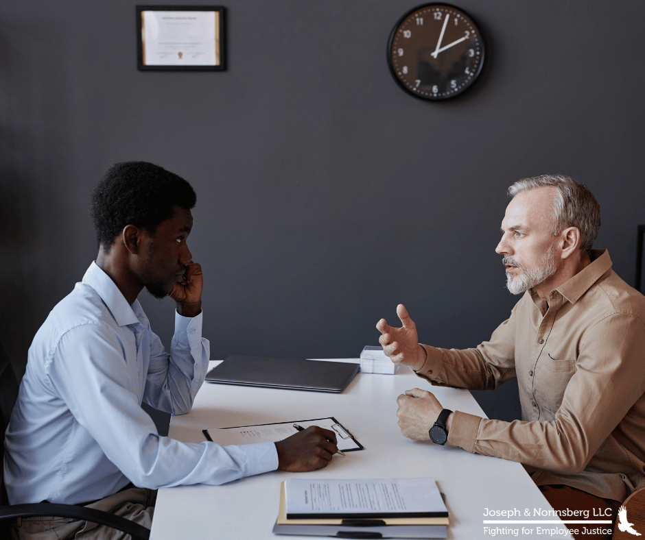 Two individuals speaking over a desk
