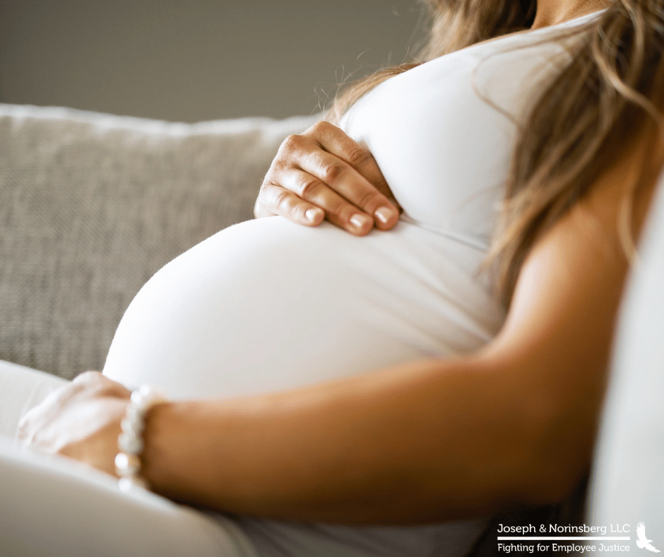 Close up of woman clutching her pregnant belly
